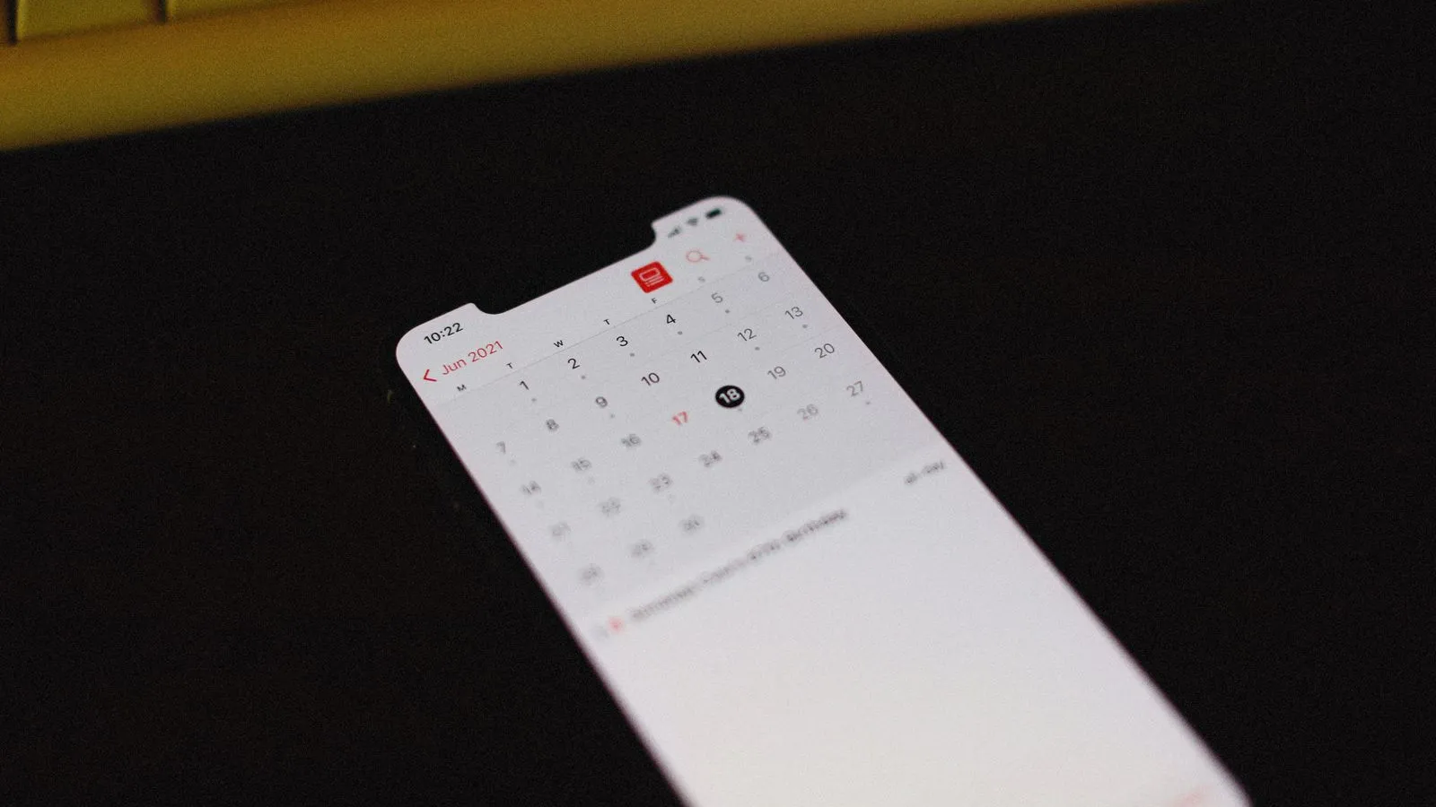 Telemóvel pousado numa mesa com o calendário aberto e um dia do mês assinalado.